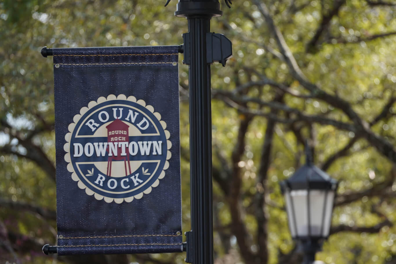 An image of a street pole with a banner showing the Downtown Round Rock logo.