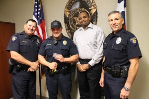 Officer Randall Frederick receives the Challenge Coin. Presenting the award are, from left, Assistant Chief Troy Evans, Chief Allen Banks and Assistant Chief Alain Babin.