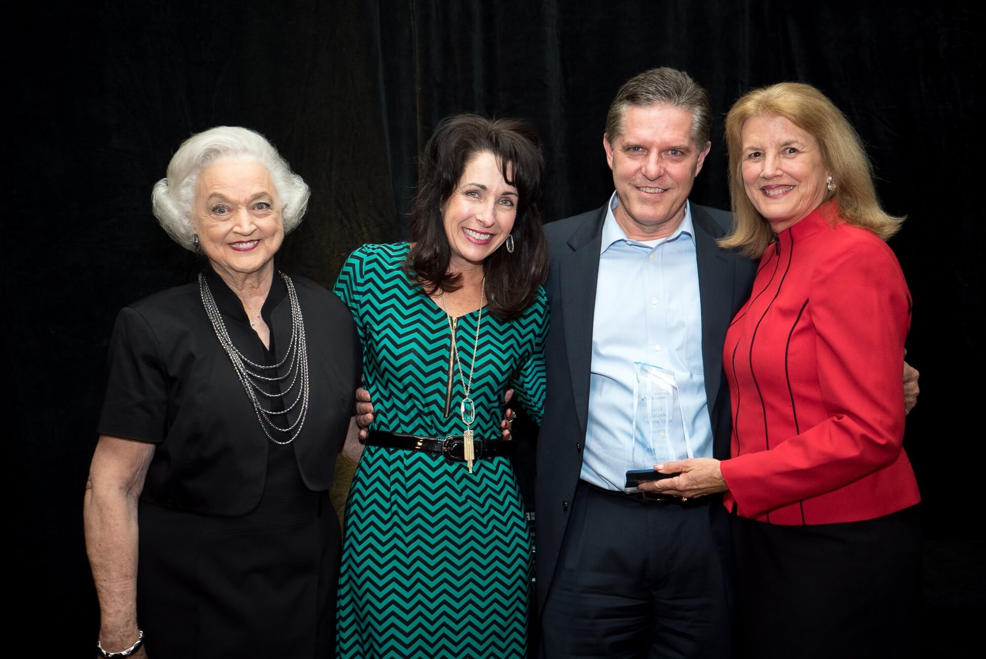 Mayor Alan McGraw accepts the award from Chamber Chair Lora Weber, right. Joining the Mayor are his wife, Kathie, and his mother, name.