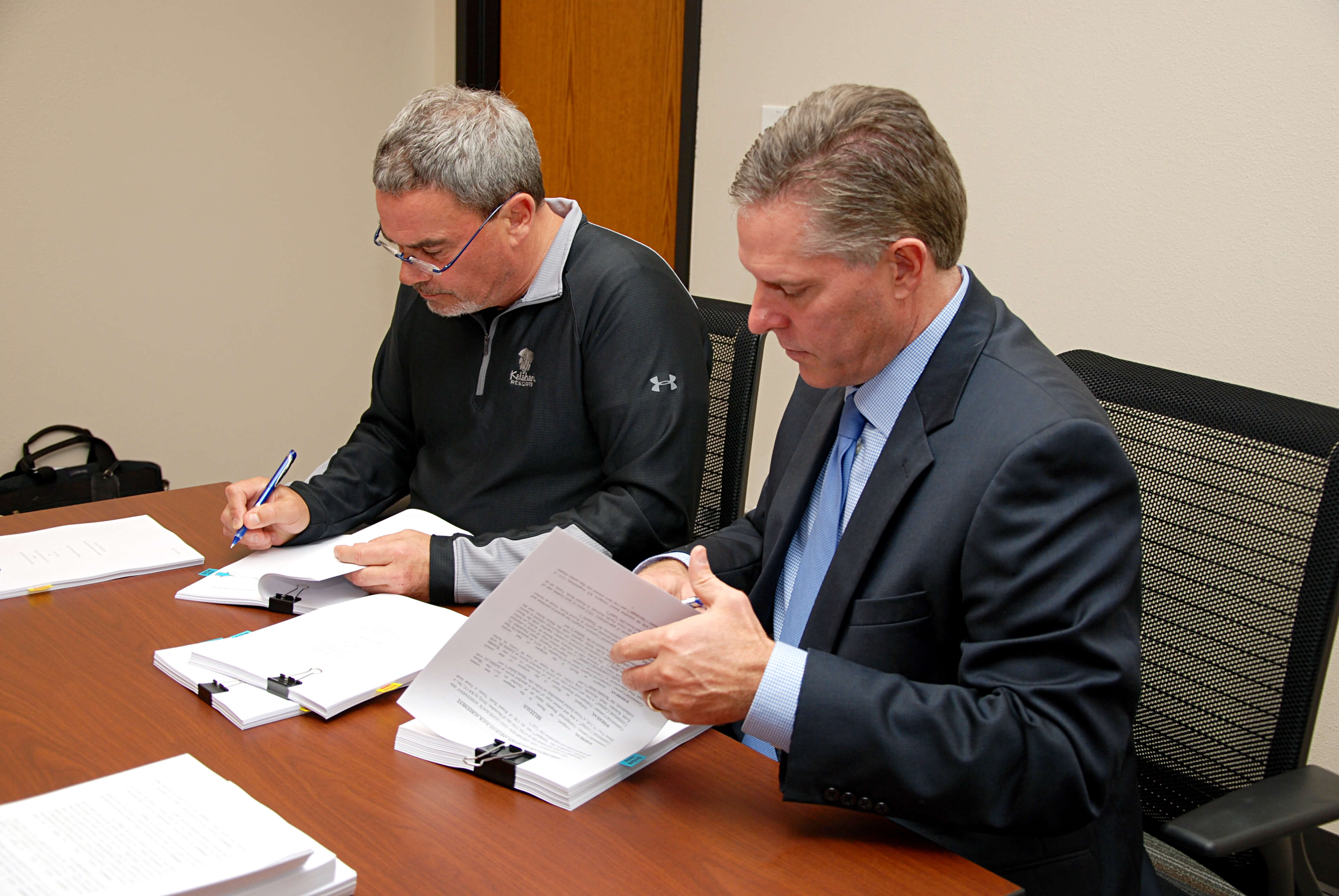 Mayor Alan McGraw, right, and Kalahari owner Todd Nelson sign agreements after the Dec. 15 City Council Meeting.