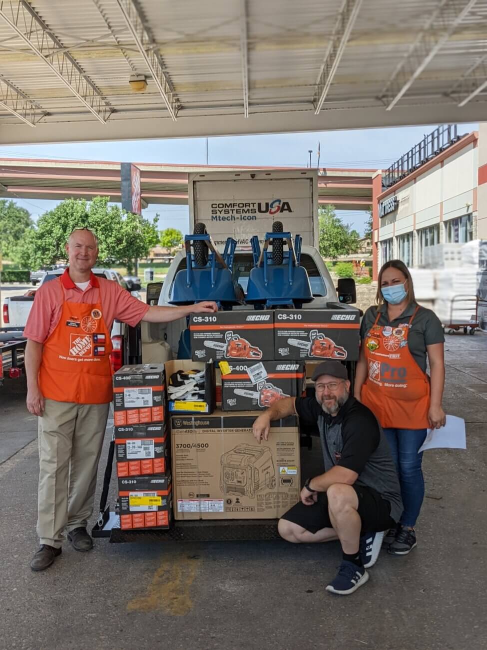 Home depot staff poses for a photo in front of donations given to the Round Rock community impacted by the March 21 tornado