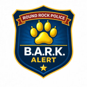 A blue and gold police badge with a yellow paw print, the words ROUND ROCK POLICE on a red banner, and B.A.R.K. ALERT in white letters with a gold star below.