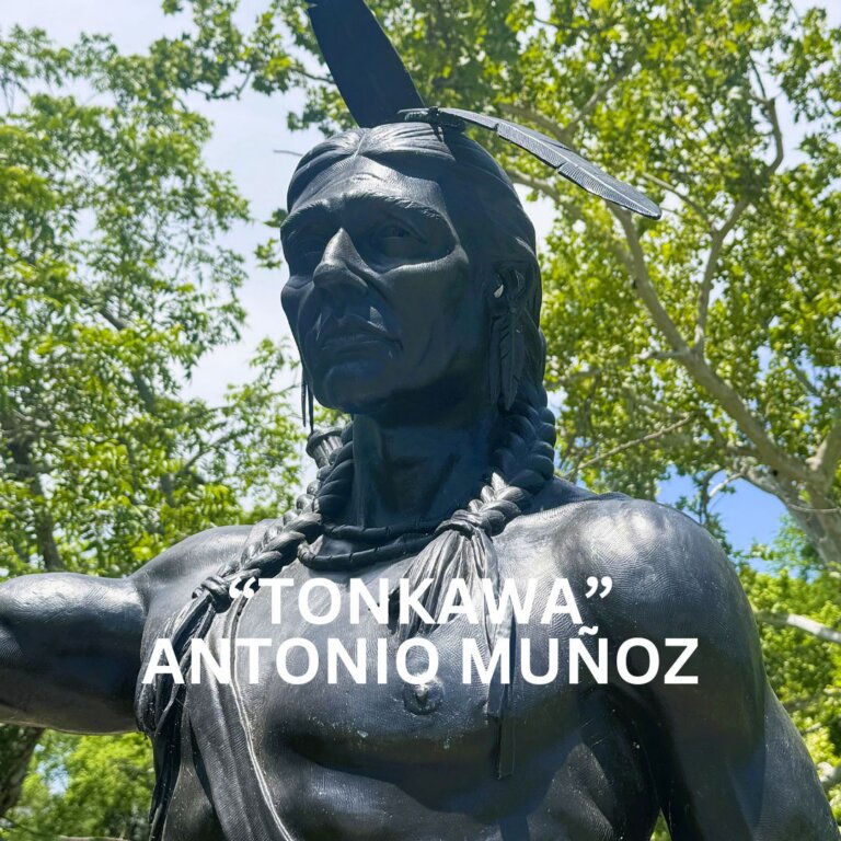 A bronze statue of a Native American man with a feather in his hair and braided necklace stands outdoors, surrounded by green trees; text reads: Tonkawa Antonio Muñoz.