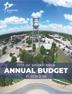 Aerial view of Round Rock, Texas, featuring a central water tower labeled Round Rock. Text overlay reads: City of Round Rock Annual Budget FY 2025–2026. Blue sky with clouds is visible above the city.