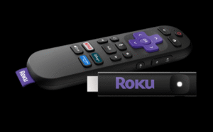 A Roku streaming stick and its remote control featuring a purple directional pad and dedicated streaming service buttons.
