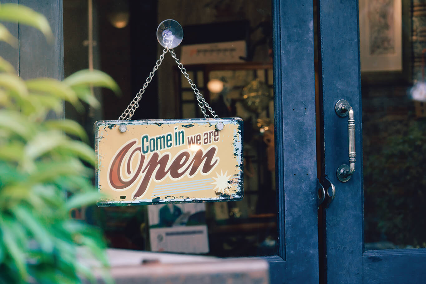A glass door with a sign that reads, "Come in we're open."
